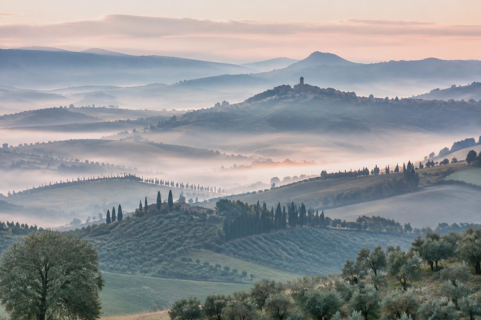 Colline umbre nella nebbia del mattino